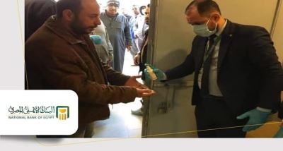 صور|عملاء البنك الأهلي وموظفوه يلتزمون بتعليمات الوقاية من الكورونا داخل الفروع